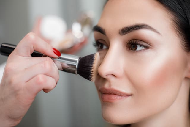 Asian girl getting airbrush makeup