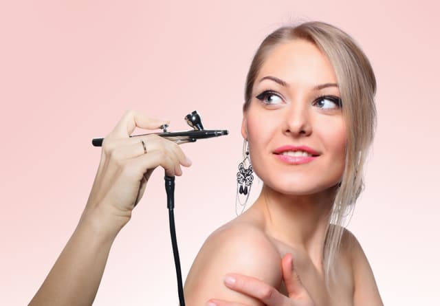 Asian girl getting airbrush makeup